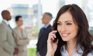 Young businesswoman talking on the mobile phone while showing a beaming smile